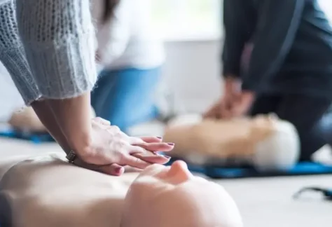 An image of someone practicing CPR on a medical dummy