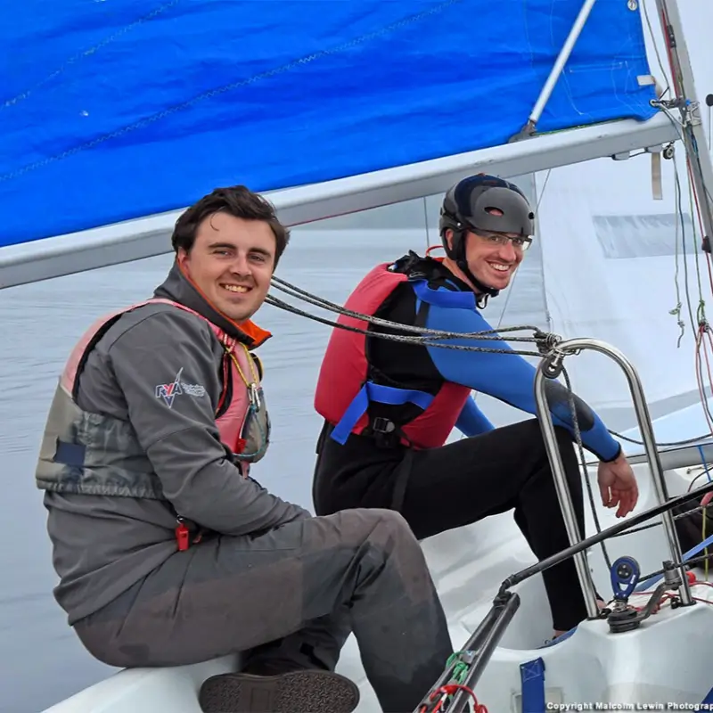 An adult in a dinghy with an instructor learning to sail at Draycote Water