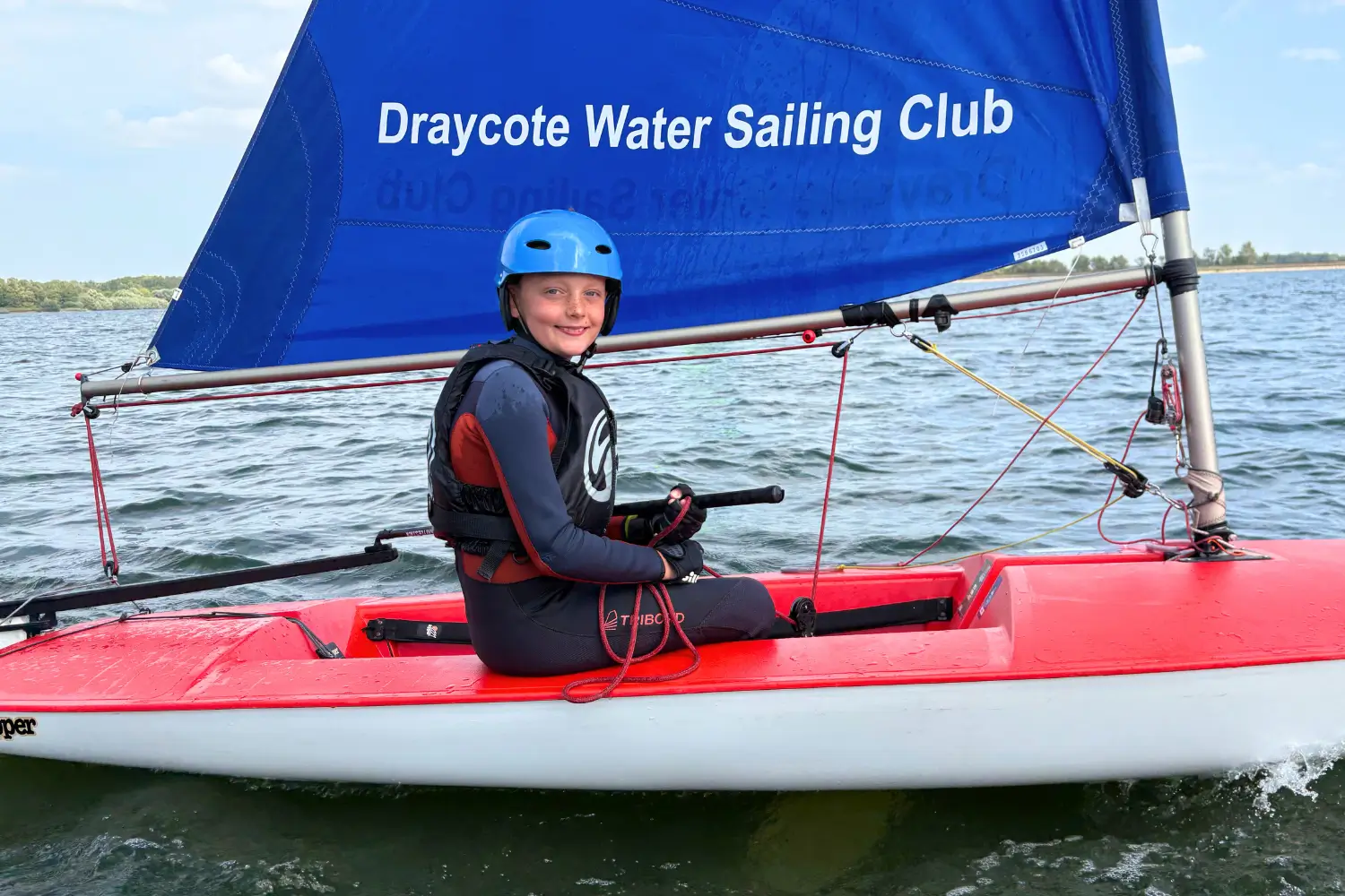 A child learning to sail a Topper dinghy
